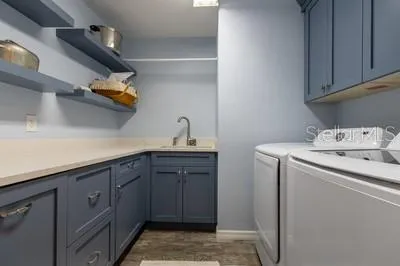 a utility room with sink dryer and washer