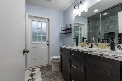 a bathroom with a granite countertop sink toilet and shower