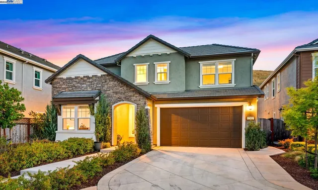 a front view of a house with yard and parking