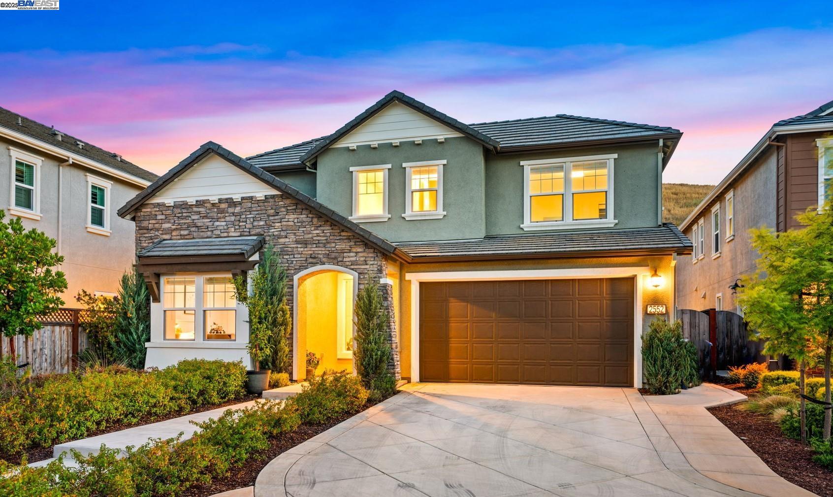 a front view of a house with yard and parking