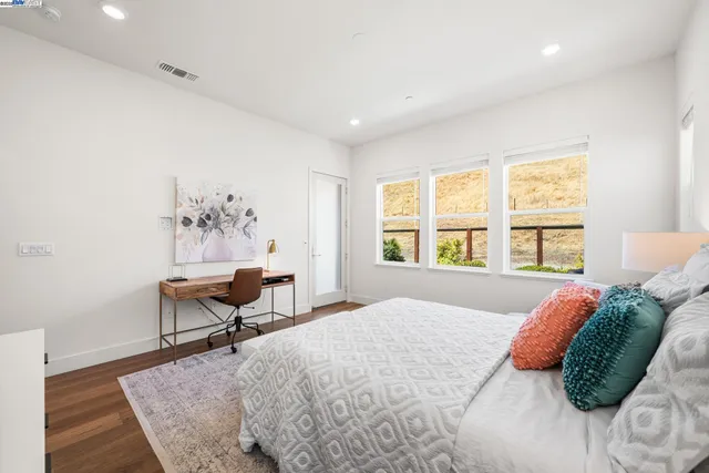 a bed sitting in a bedroom next to a window