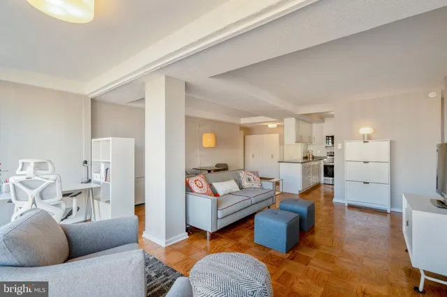 a living room with furniture and view of kitchen