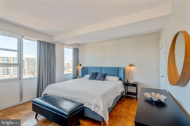 a bedroom with a bed a mirror and a window