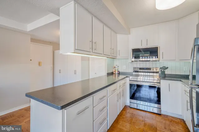 a kitchen with granite countertop a sink and white cabinets