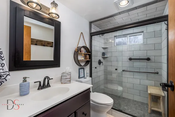 a bathroom with a granite countertop sink mirror toilet and shower