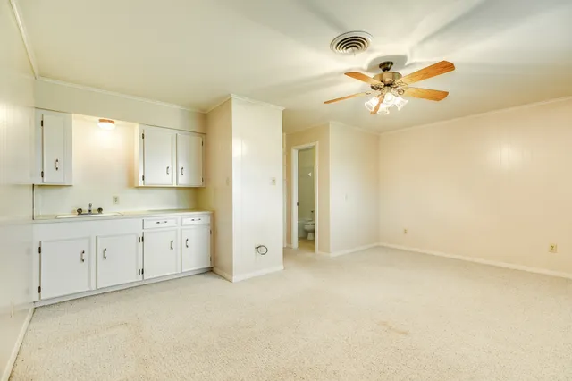 a view of a big room with chandelier fan and windows