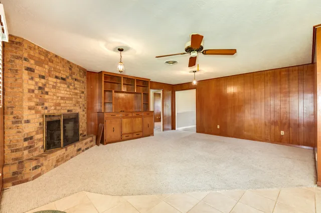 a view of a livingroom with a chandelier fan and windows