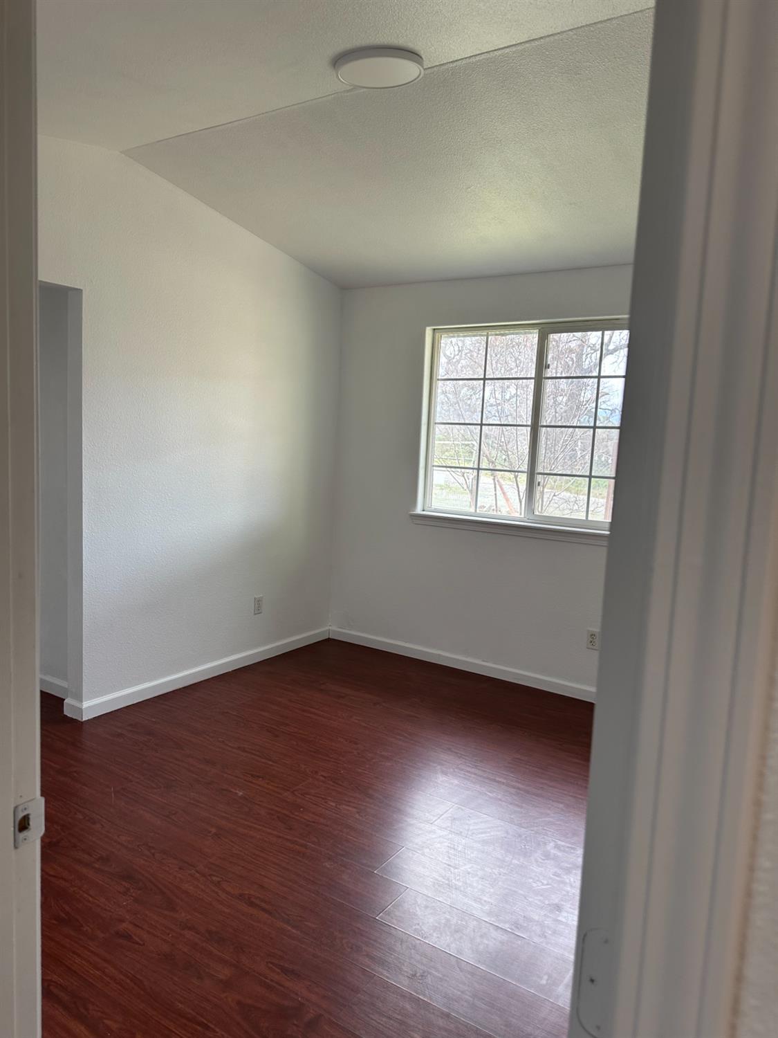 16164 Nugget Road Corning, CA 96021 - Photo 32 of 53 an empty room with wooden floor and windows