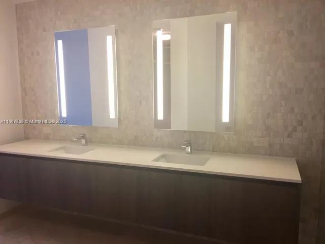 a bathroom with a double vanity sink and mirror