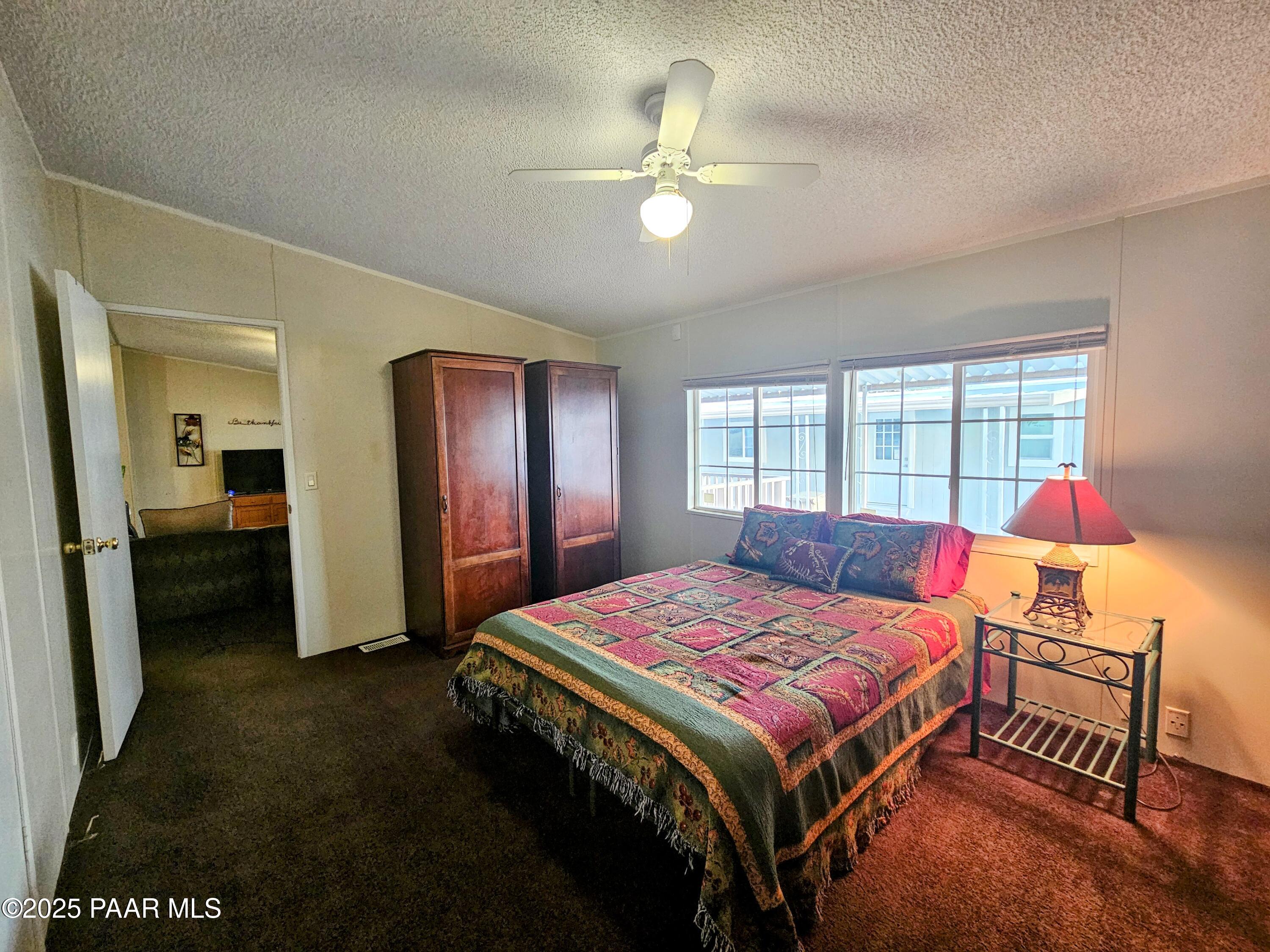 16225 North 29th Street, Unit 26 Phoenix, AZ 85032 - Photo 7 of 12 a bedroom with a bed and a chandelier