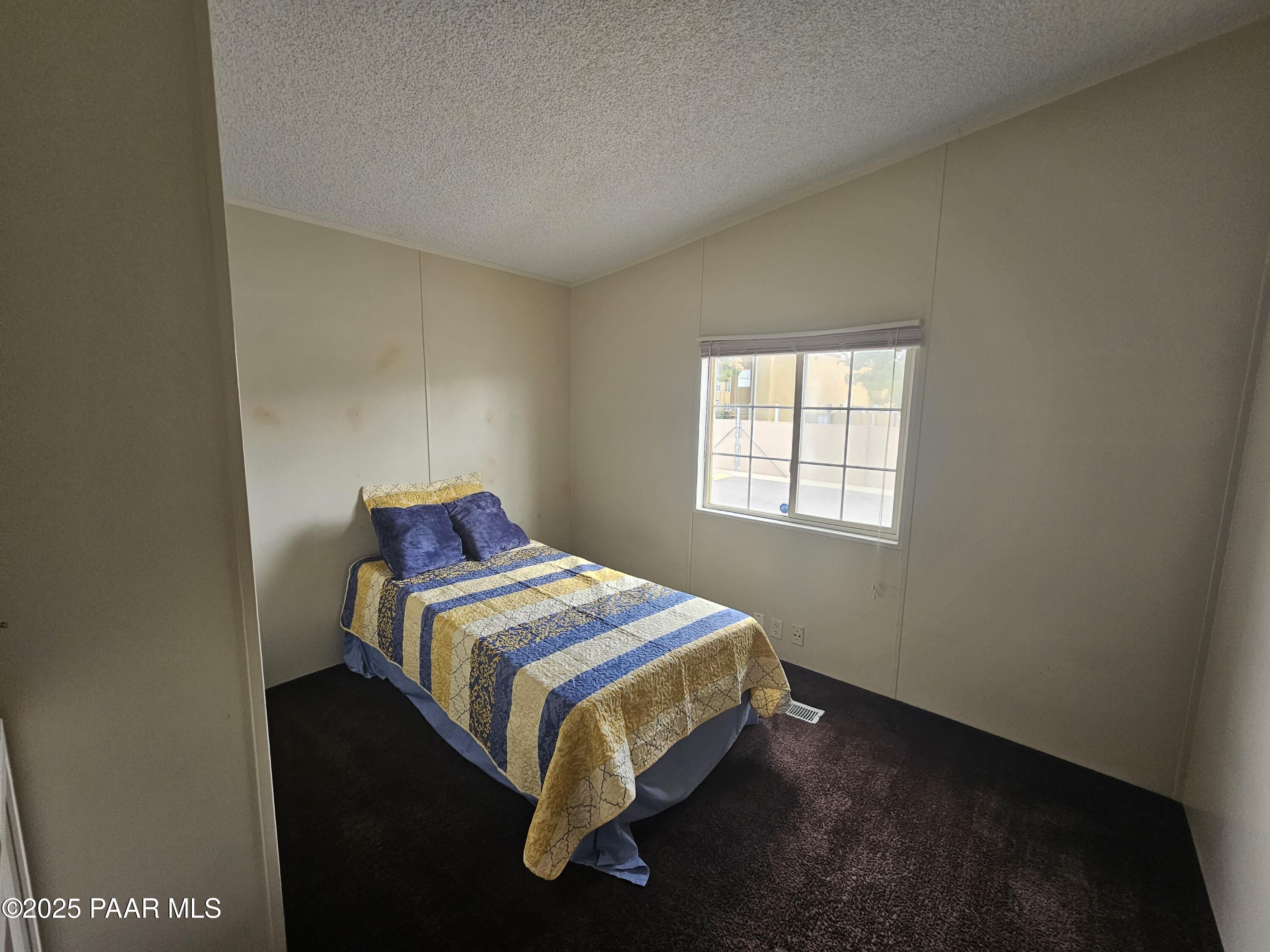 16225 North 29th Street, Unit 26 Phoenix, AZ 85032 - Photo 8 of 12 a bed sitting in a bedroom next to a window