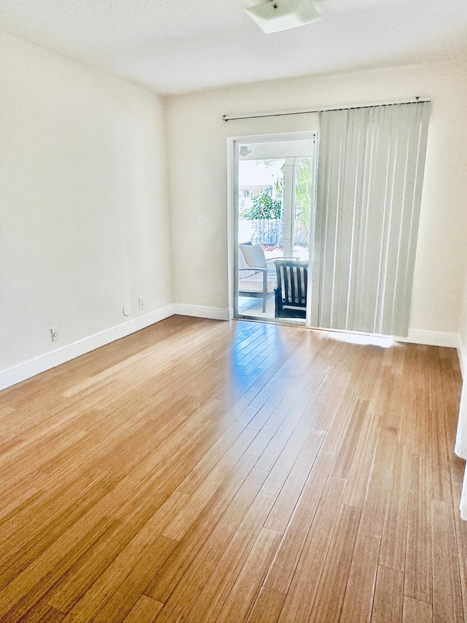 17768 Maplewood Drive Boca Raton, FL 33487 - Photo 20 of 50 an empty room with wooden floor and a window