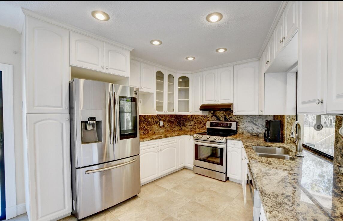 17768 Maplewood Drive Boca Raton, FL 33487 - Photo 21 of 50 a kitchen with stainless steel appliances granite countertop a refrigerator sink and stove