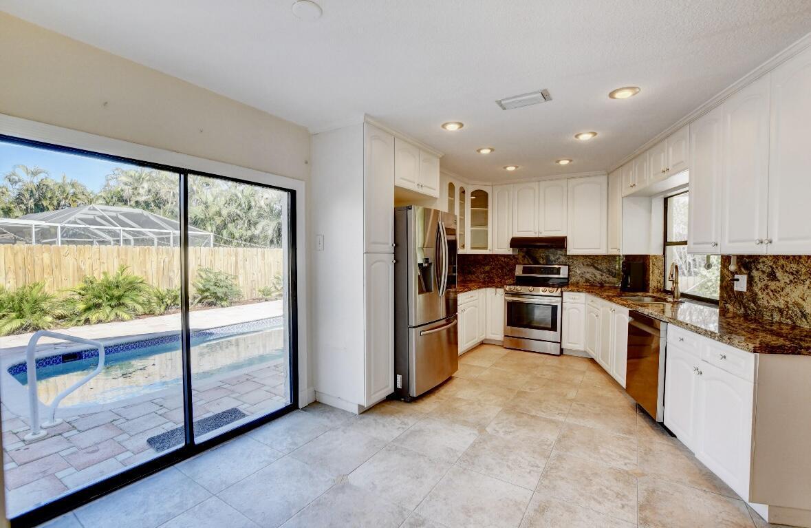 17768 Maplewood Drive Boca Raton, FL 33487 - Photo 22 of 50 a kitchen with stainless steel appliances granite countertop a refrigerator and a stove top oven