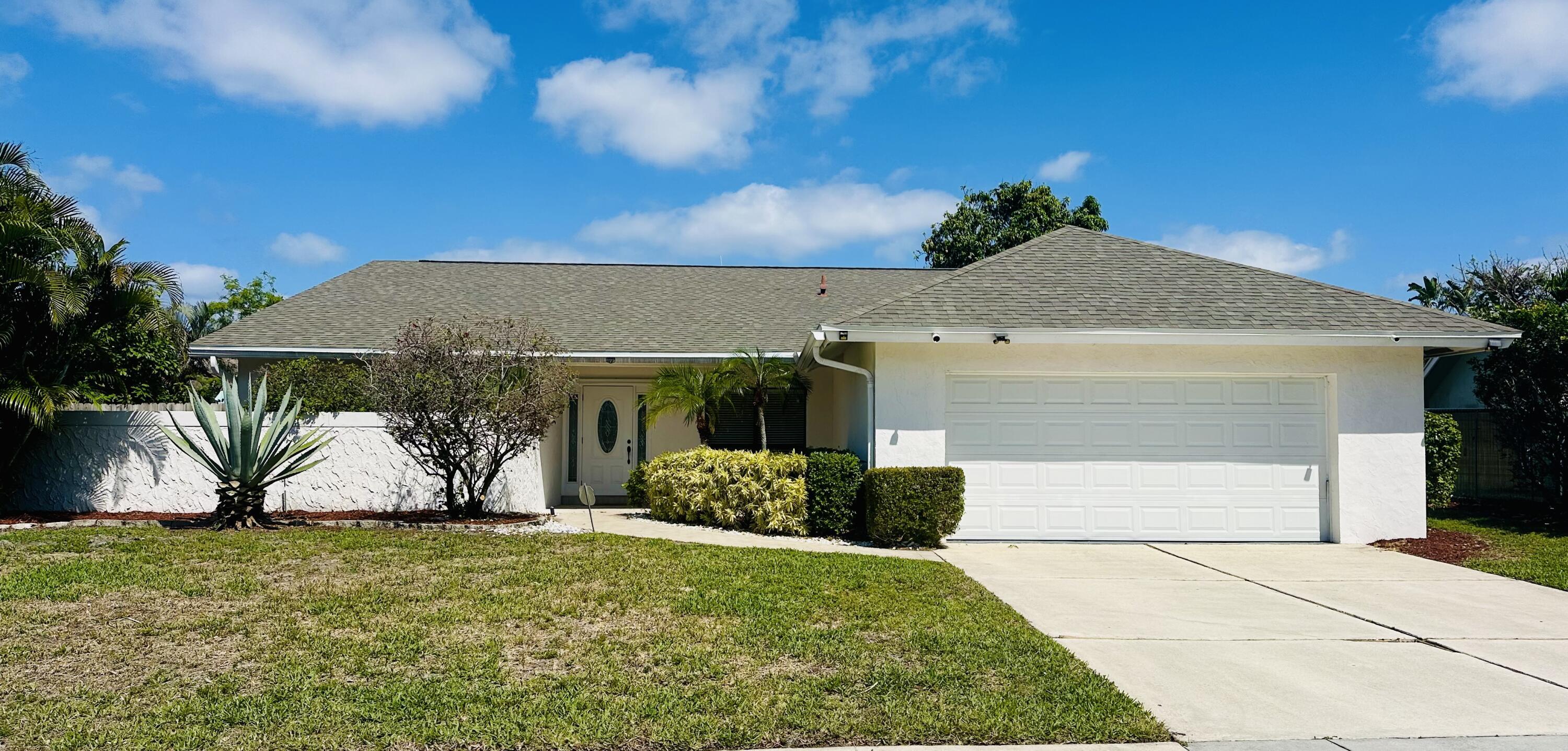 17768 Maplewood Drive Boca Raton, FL 33487 - Photo 4 of 50 a front view of a house with a yard and garage