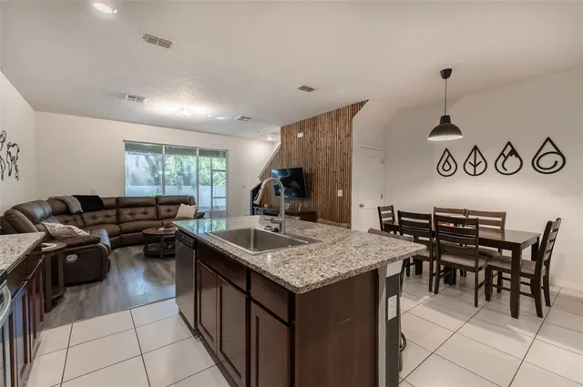 a kitchen with a stove a kitchen island a dining table and chairs
