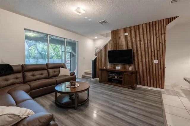 a living room with furniture a flat screen tv and a large window
