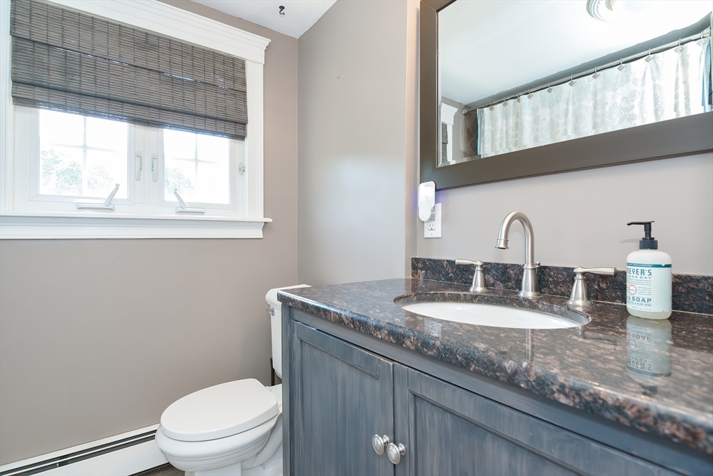 633 Williams Street Dighton, MA 02764 - Photo 24 of 41 a bathroom with a granite countertop toilet a sink and a window