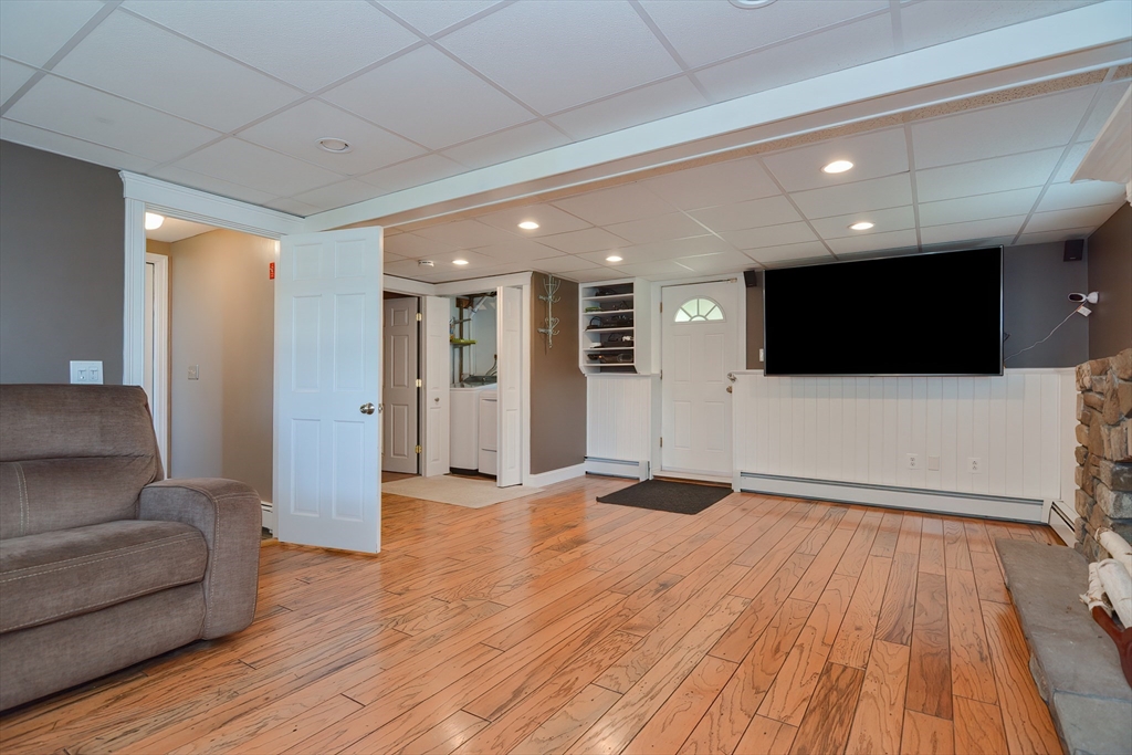 633 Williams Street Dighton, MA 02764 - Photo 31 of 41 a view of a livingroom with a flat screen tv wooden floor and staircase