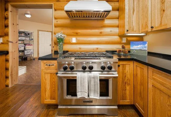 a kitchen with stainless steel appliances a dining table chairs refrigerator and sink