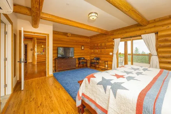 a bedroom with a bed and a flat tv screen on dresser