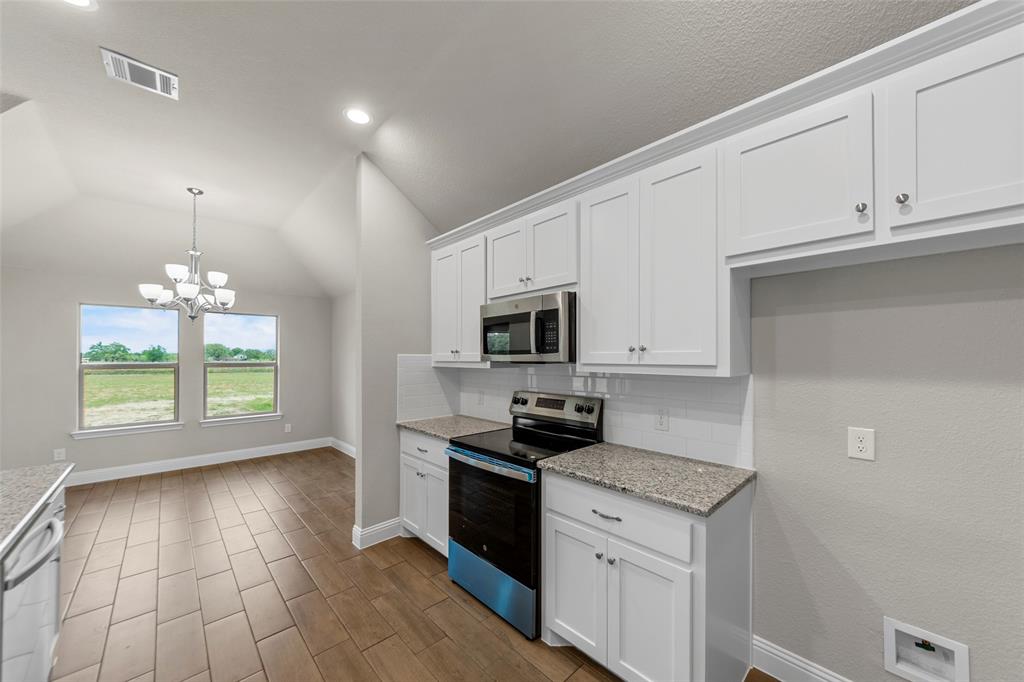 18310 Chippewa Court Terrell, TX 75160 - Photo 13 of 35 a kitchen with granite countertop stainless steel appliances a stove a sink a microwave and cabinets
