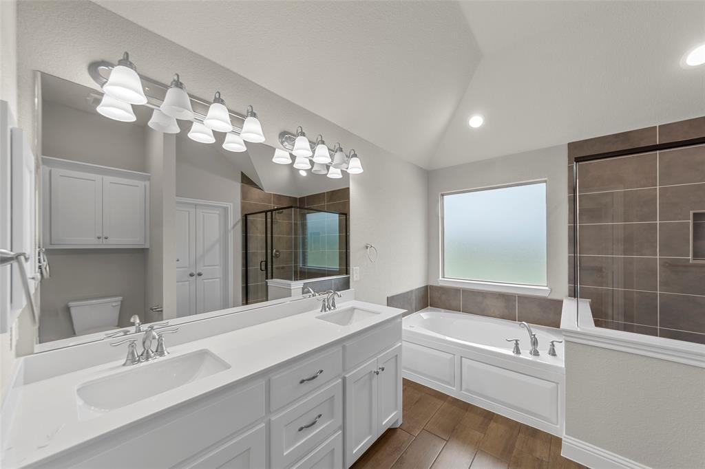 18310 Chippewa Court Terrell, TX 75160 - Photo 26 of 35 a bathroom with a double vanity sink bathtub and a mirror