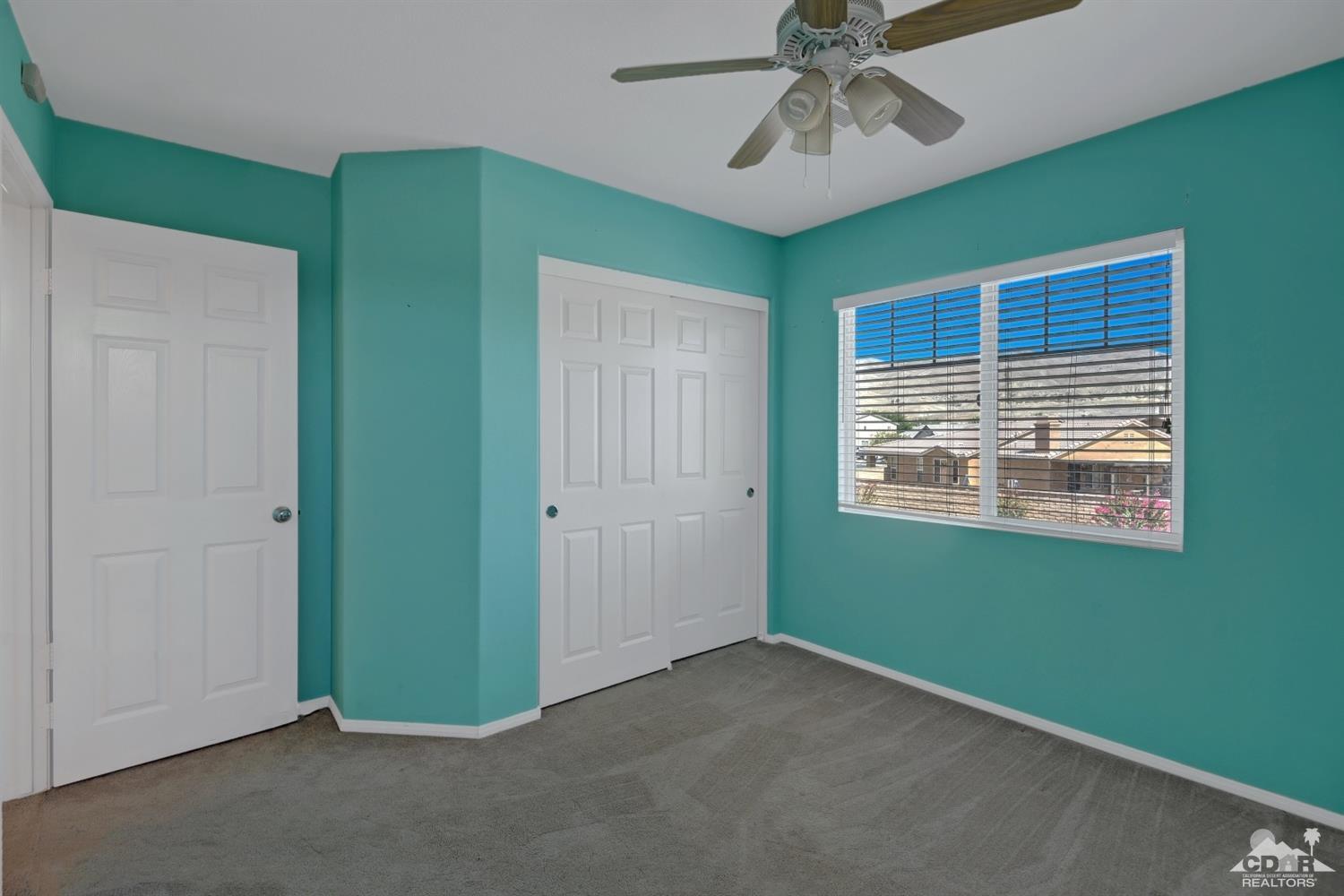 37773 Caprice Drive Indio, CA 92203 - Photo 18 of 26 a view of an empty room with window and chandelier fan