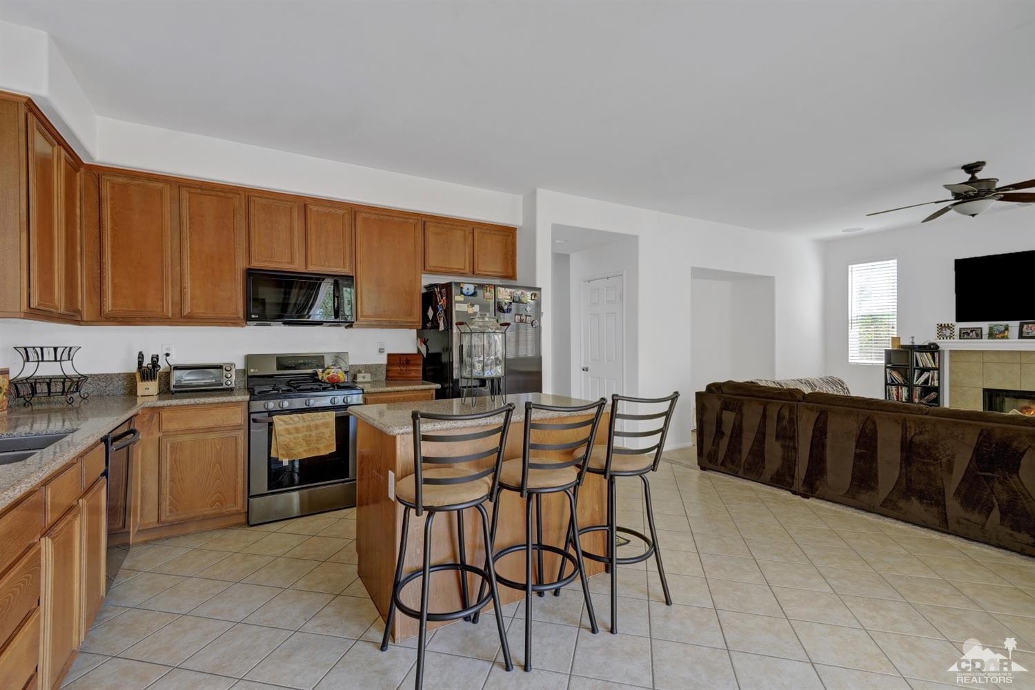 37773 Caprice Drive Indio, CA 92203 - Photo 8 of 26 a kitchen with stainless steel appliances granite countertop a sink a stove a microwave a counter top space and cabinets