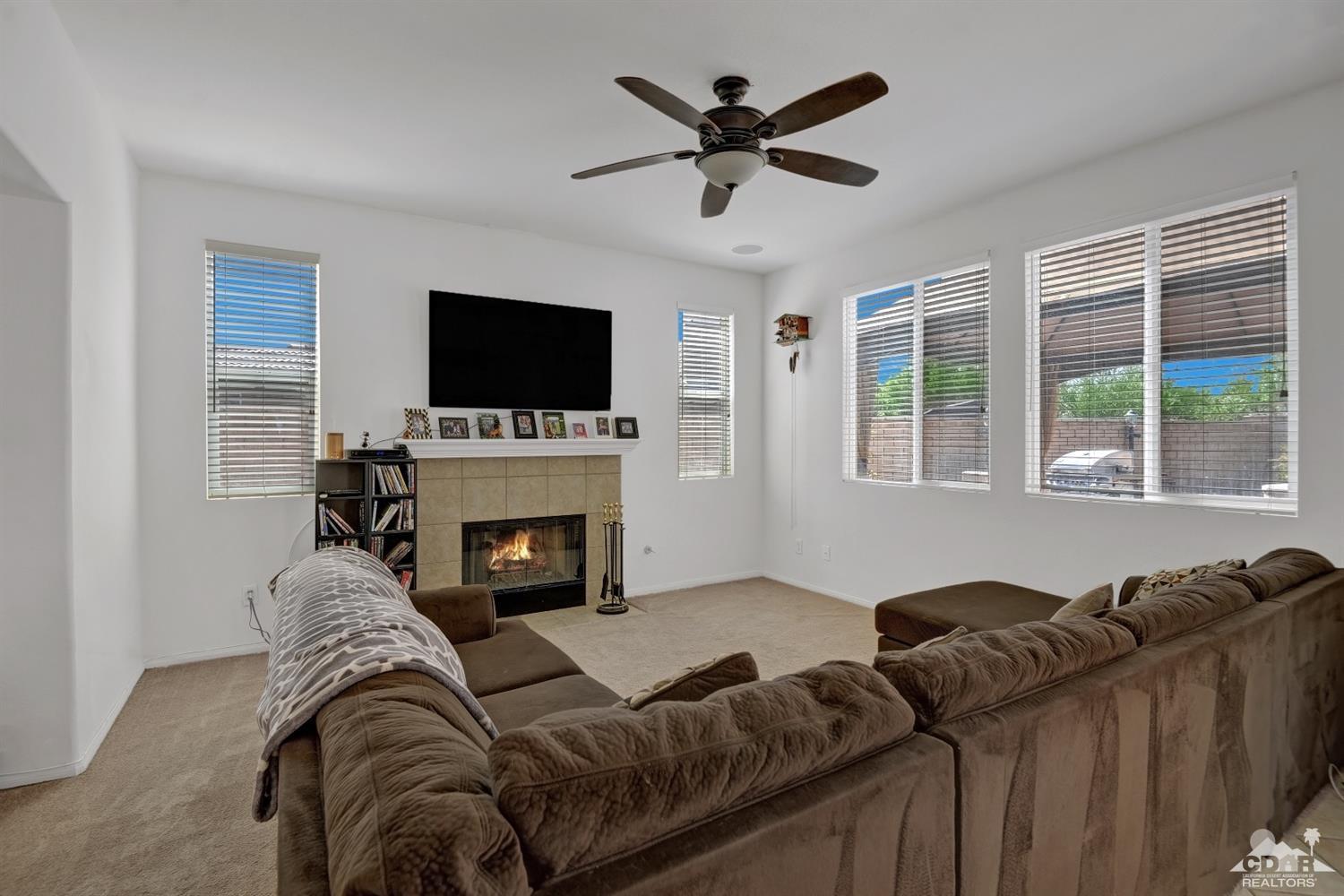 37773 Caprice Drive Indio, CA 92203 - Photo 9 of 26 a living room with furniture a fireplace and a flat screen tv