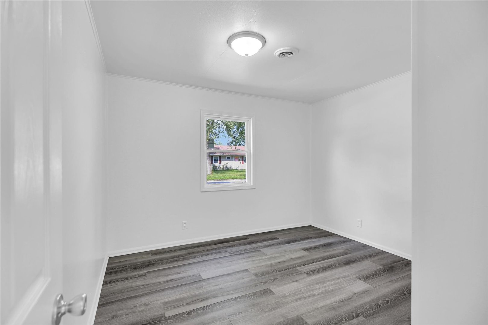 804 Juniper Drive Rantoul, IL 61866 - Photo 14 of 24 an empty room with wooden floor and windows