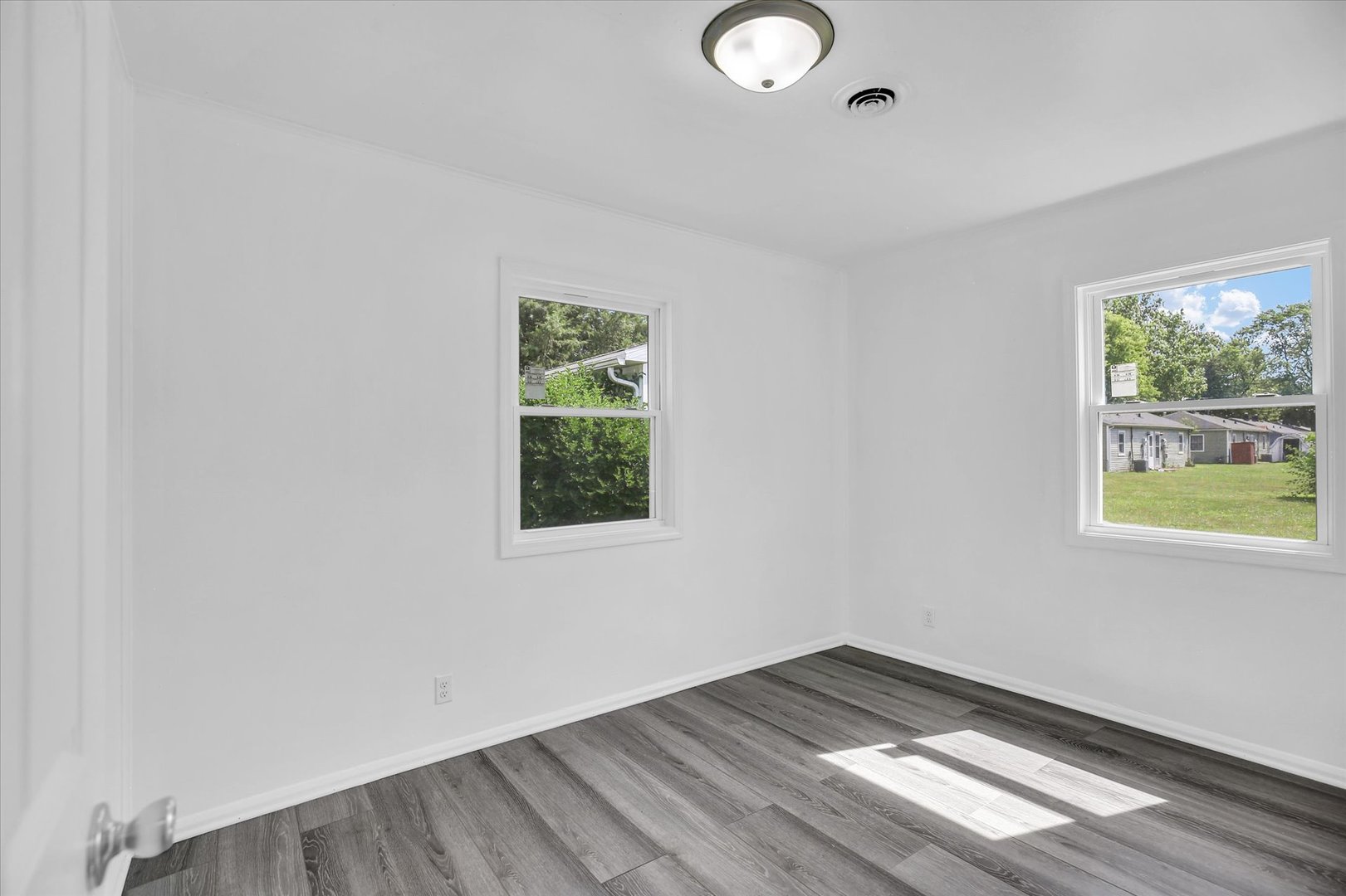 804 Juniper Drive Rantoul, IL 61866 - Photo 16 of 24 an empty room with wooden floor and windows
