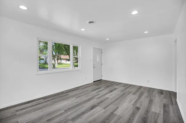 a view of empty room with wooden floor