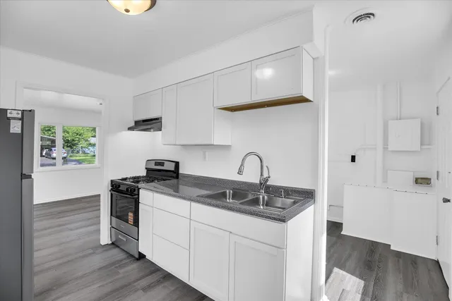 a kitchen with stainless steel appliances granite countertop a sink and a refrigerator