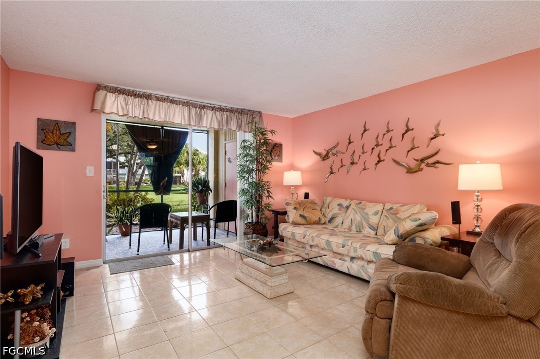 5959 Winkler Road, Unit 103 Fort Myers, FL 33919 - Photo 11 of 24 a living room with furniture and a flat screen tv