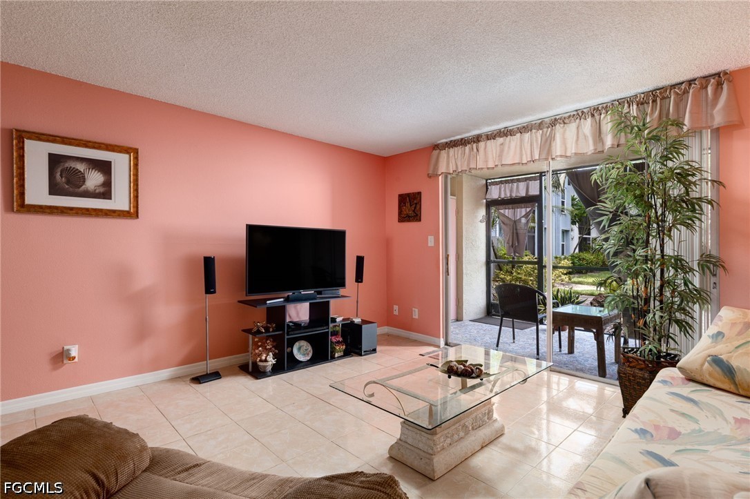 5959 Winkler Road, Unit 103 Fort Myers, FL 33919 - Photo 12 of 24 a living room with furniture and a flat screen tv