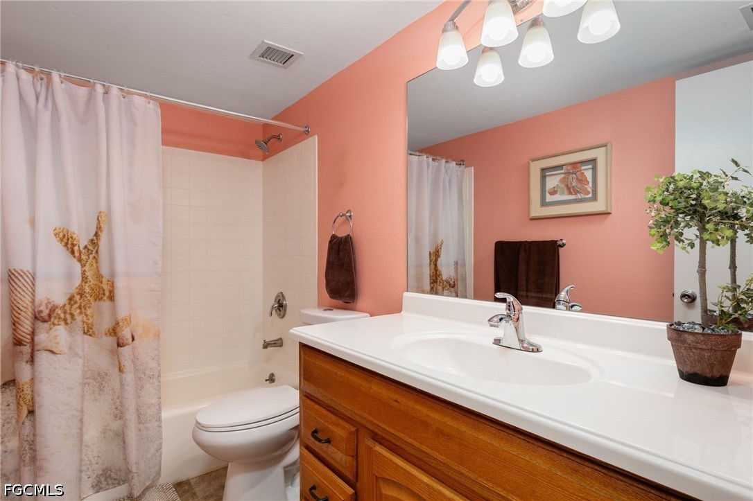 5959 Winkler Road, Unit 103 Fort Myers, FL 33919 - Photo 19 of 24 a bathroom with a sink a toilet and shower curtain