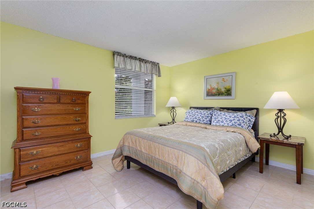 5959 Winkler Road, Unit 103 Fort Myers, FL 33919 - Photo 20 of 24 a bedroom with a bed and a painting on the wall