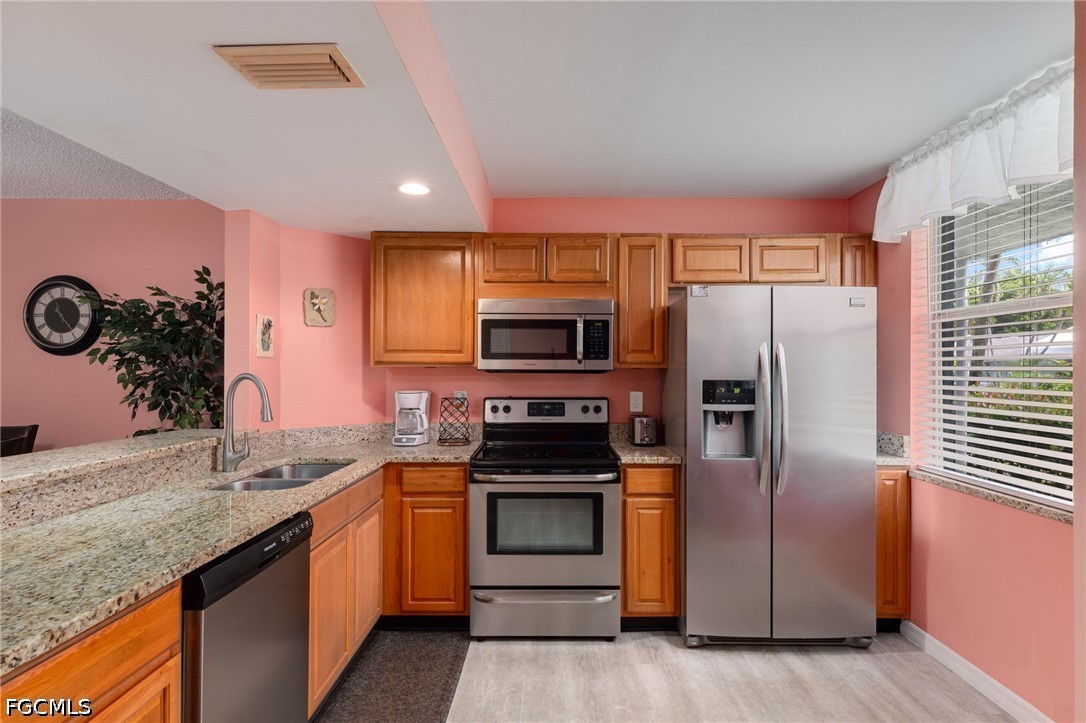 5959 Winkler Road, Unit 103 Fort Myers, FL 33919 - Photo 7 of 24 a kitchen with stainless steel appliances granite countertop a refrigerator and a stove