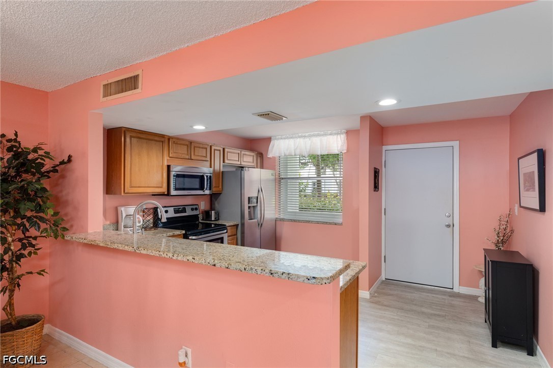 5959 Winkler Road, Unit 103 Fort Myers, FL 33919 - Photo 8 of 24 a kitchen with sink a window and chairs