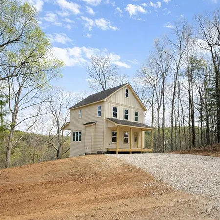 a view of a large white house with a big yard and large trees