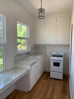 a walk in closet with white cabinets