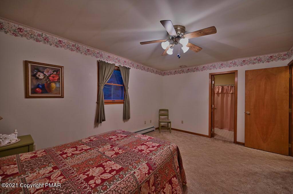 168 Shenkel Road Effort, PA 18330 - Photo 26 of 64 a bedroom with a large bed and a chandelier