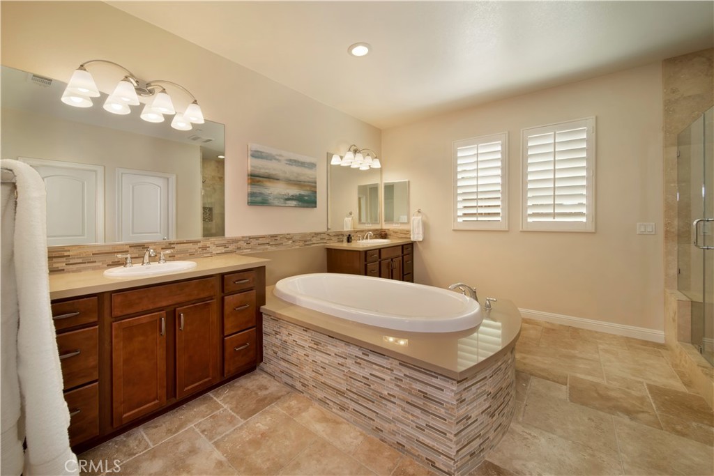 5572 Thoroughbred Street Oceanside, CA 92057 - Photo 13 of 38 a spacious bathroom with a double vanity sink a large mirror and a bathtub