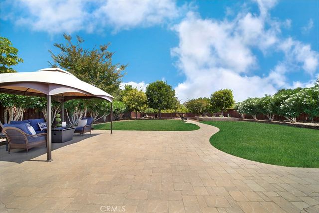 a backyard of a house with fireplace table and chairs