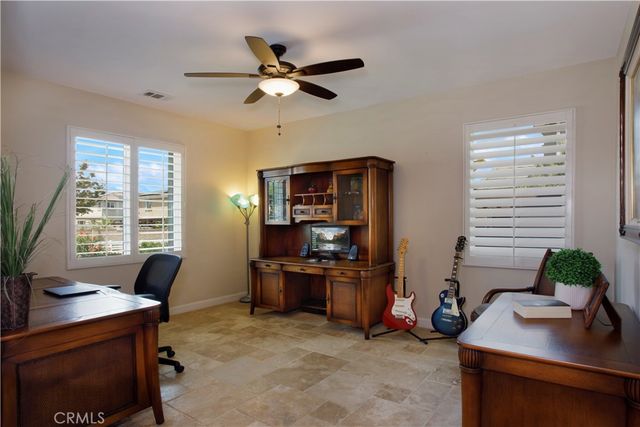 a view of a workspace with furniture and a window
