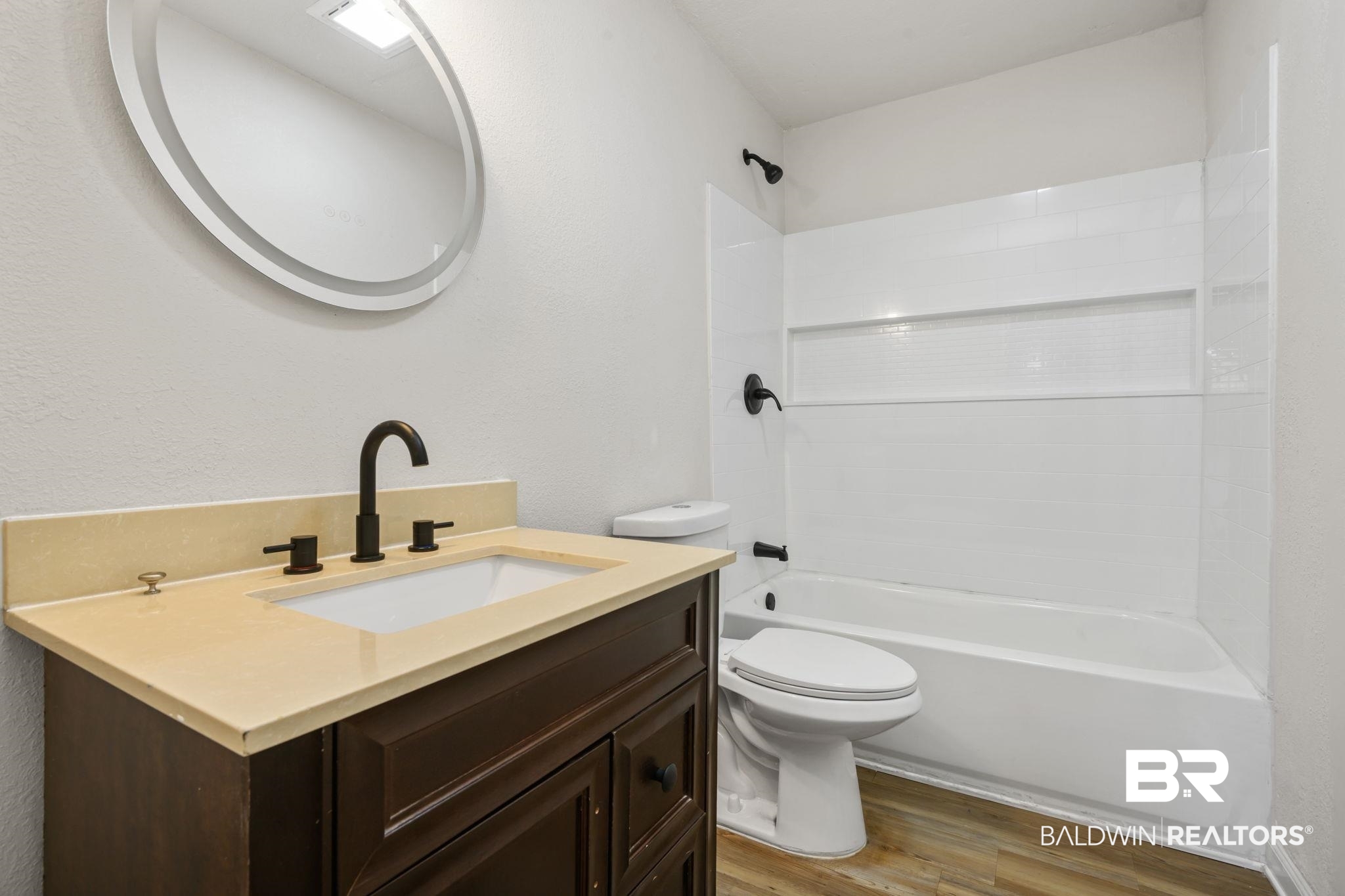 910 Moran Street Bay Minette, AL 36507 - Photo 14 of 20 Bathroom featuring vanity, washtub / shower combination, light wood-style floors, and a textured wall