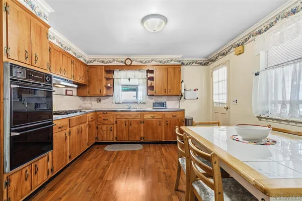 a kitchen with a sink and wooden floor