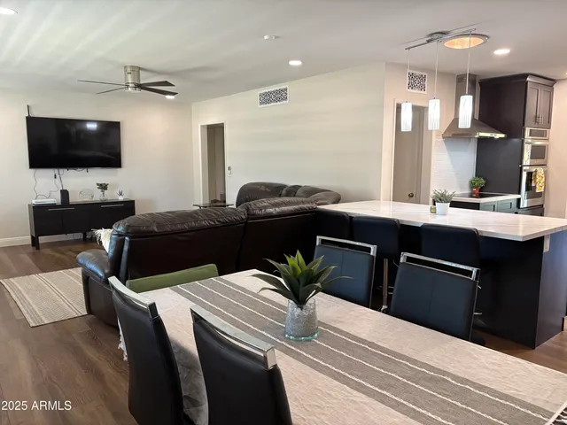 a kitchen with a table chairs refrigerator and a television