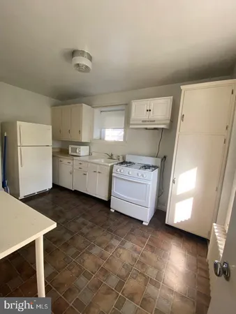 a kitchen with a stove a refrigerator and a sink